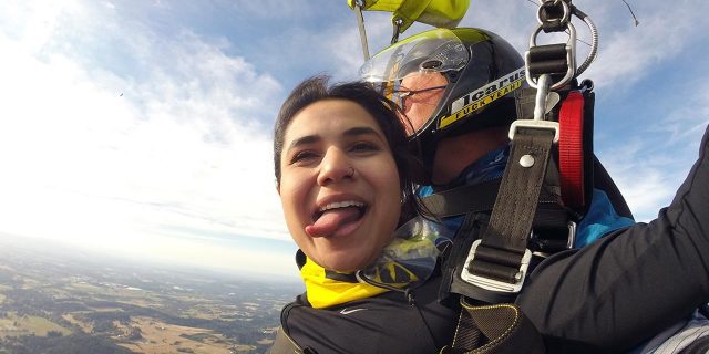 young woman smiles with tongue out under yellow canopy