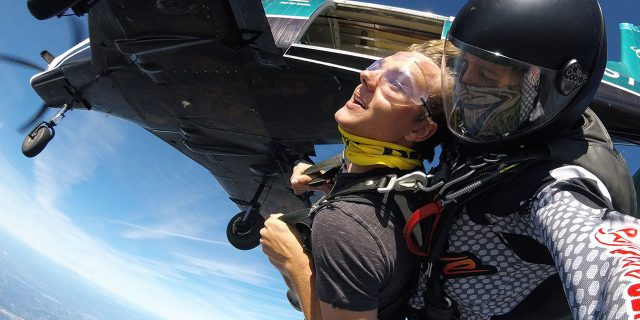 young man just after existing plane for first skydive