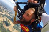 Man wearing superman shirt tandem skydiving at PNW Skydiving in Oregon