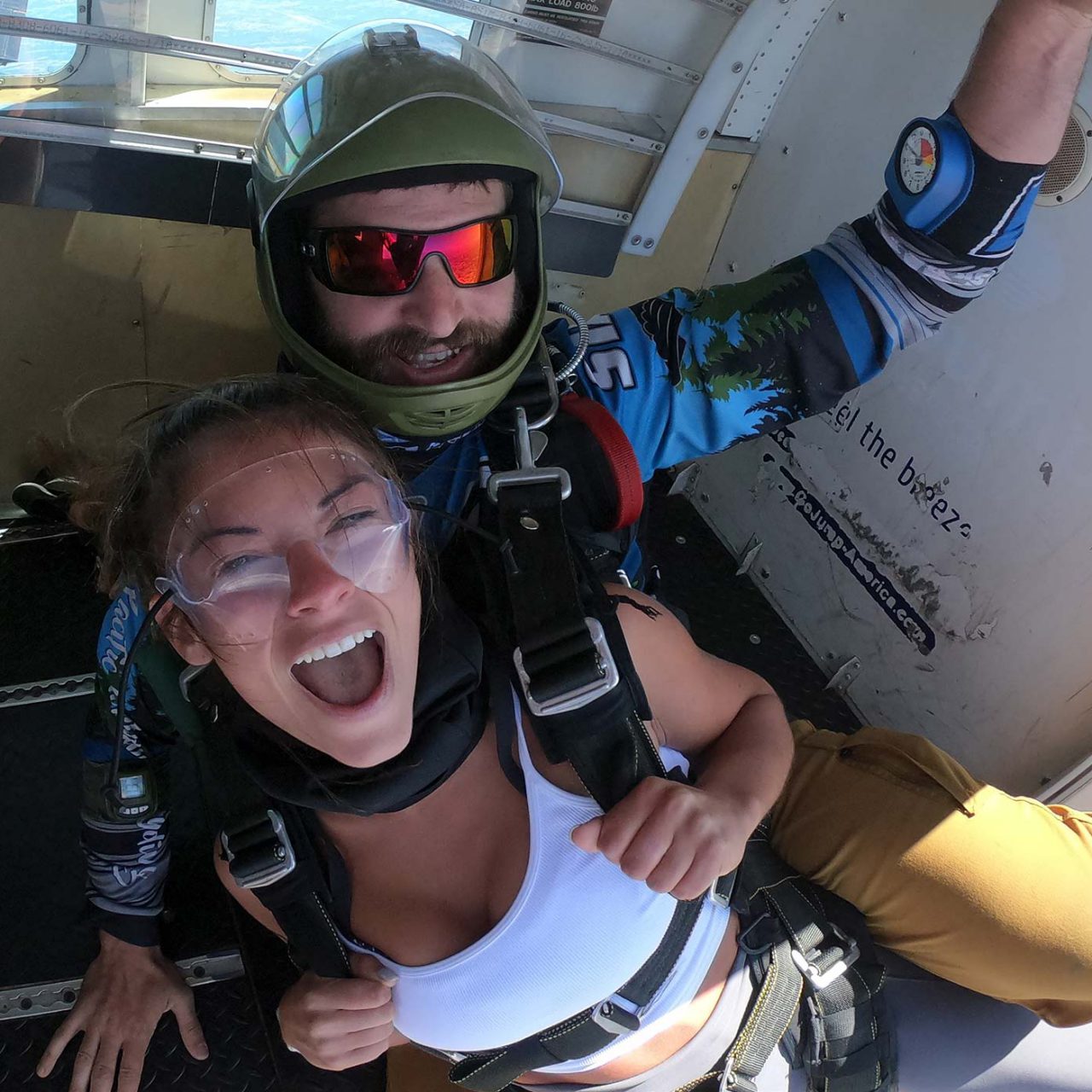 Smiling female tandem student and instructor in doorway of aircraft above PNW Skydiving in Oregon