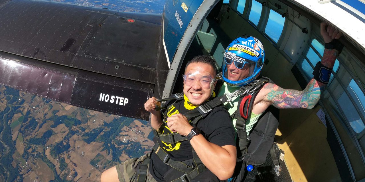 Male tandem skydiving student and instructor exiting aircraft above PNW Skydiving Center near Portland, OR