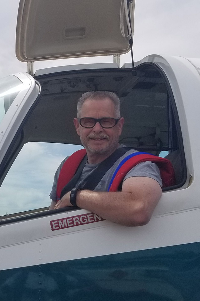 Rodney Haddon smiles out the window of the jump plane